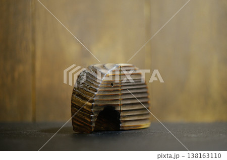 Horizontal three-quarter view of a stylized wooden elephant sculpture with a burnt striped texture, highlighting the relief carving and natural wood tones. 138163110