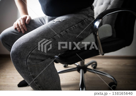 Man sits on orthopedic cushion for back pain relief, posture correction, spinal health. Device for disc herniation, osteochondrosis, sacral pain. 138165640