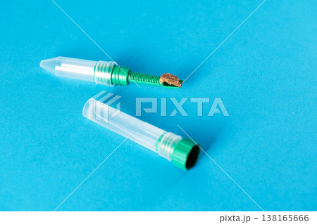 Stool sample in a test tube with a spatula on a blue background. Concept of stool testing for dysbiosis. Copy space for text 138165666