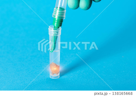 A doctor's hand drops a stool sample into a test tube for irritable bowel syndrome stool analysis. Copy space for text A doctor's hand drops a stool sample into a test tube for irritable bowel syndrome stool analysis. Copy space for text 138165668