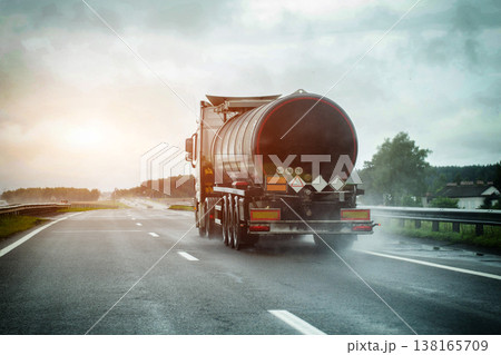 Large tanker truck driving on wet highway amidst heavy rain, water spray from wheels, poor visibility conditions, potential road hazard, cargo transport. Copy space for text 138165709