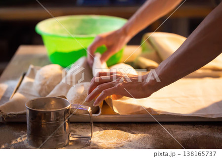 Person hands working with dough on wooden table making bread baking preparation culinary process kitchen activity food production homemade meal 138165737