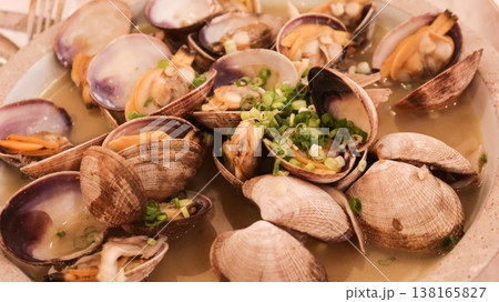 close up of Chinese steamed clams served in light broth, garnished with chopped green onions on a plate close up of Chinese steamed clams served in light broth, garnished with chopped green onions on a plate 138165827