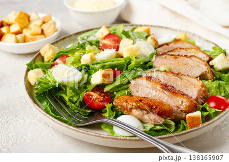 Caesar salad, with duck breast, on a light plate, on a light background, homemade, no people, 138165907