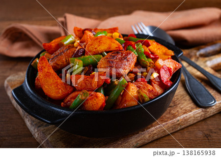 Steakhouse pfanne, fried potato slices, with meatballs, and vegetable mixture, on a black plate, 138165938