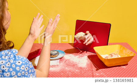 Woman clapping hands as tart appears from tablet screen on flour covered table. 138165981