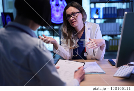 Doctor discussing treatment options with patient in a modern healthcare setting during an afternoon consultation Doctor discussing treatment options with patient in a modern healthcare setting during an afternoon consultation 138166111