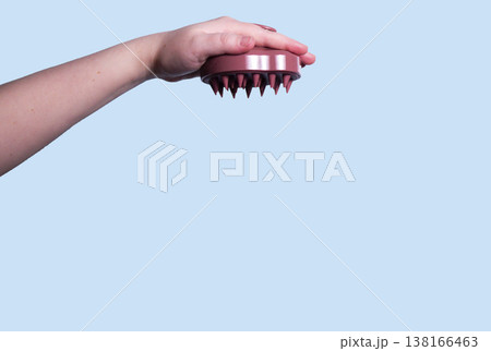 Hair pink scalp massager in woman hand on the pink background isolated. Image with copy space. Mock up for design and banner Hair pink scalp massager in woman hand on the pink background isolated. Image with copy space. Mock up for design and banner 138166463