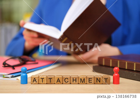 Creative connection in an office setting as a person explores a book while attachments await engagement on the desk 138166738