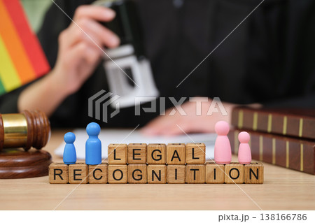 Legal recognition milestone marked by colorful tokens and a judge's stamp at a busy law office 138166786