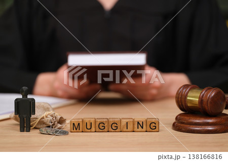 Courtroom scene reveals a tense moment of justice with a miniature figure and wooden gavel emphasizing mugging Courtroom scene reveals a tense moment of justice with a miniature figure and wooden gavel emphasizing mugging 138166816