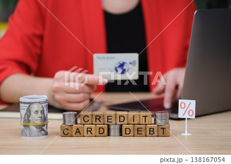 Understanding credit card debt management with finances and a laptop at a cozy workspace 138167054