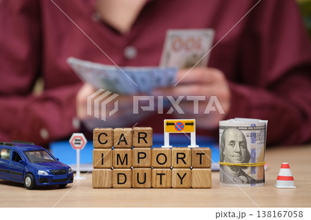 Visual representation of car import duty process with money, models, and signage conveying the trade regulations 138167058
