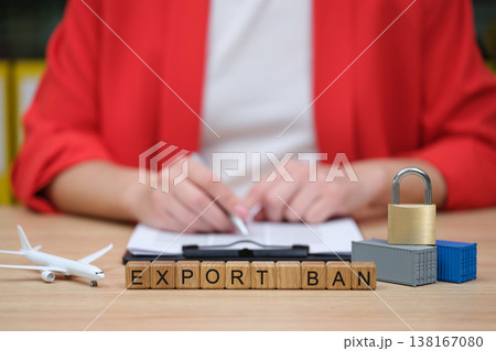 Business professional discusses export restrictions with cargo and airplane model on the desk during morning hours in a bright office 138167080