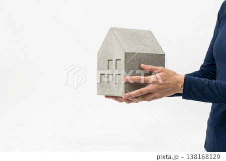 Hands Holding Concrete House Model on White Background 138168129
