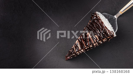 Chocolate cake slice on server over dark background with copy space Chocolate cake slice on server over dark background with copy space 138168168