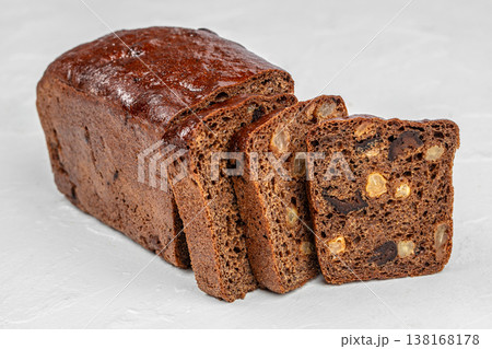 Fruit bread loaf with sliced pieces on light background 138168178