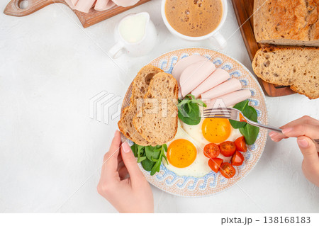 breakfast plate with fried eggs bread and sliced meat top view 138168183