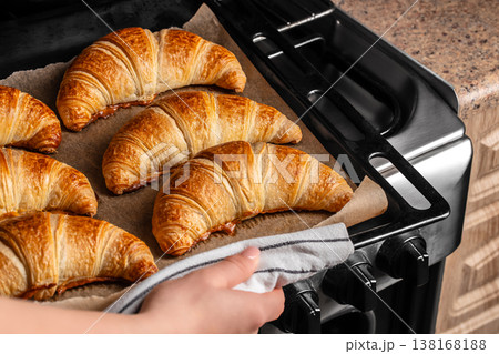 Baked croissants on oven tray, fresh homemade pastry taken from oven 138168188