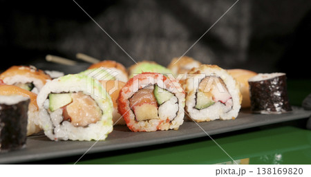 Sushi rolls are arranged on a black plate in a restaurant setting during the evening meal time Sushi rolls are arranged on a black plate in a restaurant setting during the evening meal time 138169820