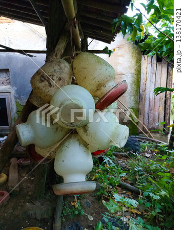 A collection of dirty plastic chicken drinking bowls hanging A collection of dirty plastic chicken drinking bowls hanging 138170421