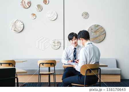 オフィスビルのフリースペースで打ち合わせをする若いビジネスマン 138170643