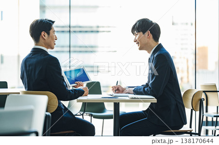 テーブルでミーティングをする若いビジネスマン テーブルでミーティングをする若いビジネスマン 138170644