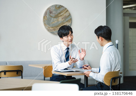 オフィスビルのフリースペースで打ち合わせをする若いビジネスマン 138170646