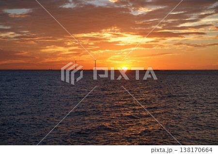 水平線に沈む夕日と黄金色に輝く海辺の夕景 水平線に沈む夕日と黄金色に輝く海辺の夕景 138170664
