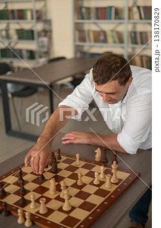 Caucasian man thinking about a chess move. Caucasian man thinking about a chess move. 138170829