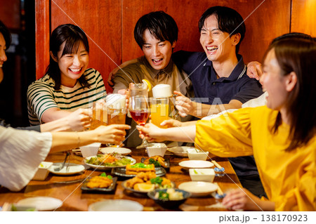 居酒屋で乾杯をする若い男女 居酒屋で乾杯をする若い男女 138170923