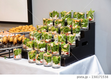 Assorted catering appetizer with caesar salad in glass verrine on buffet stand for event or party decoration with no people and copy space delicious Assorted catering appetizer with caesar salad in glass verrine on buffet stand for event or party decoration with no people and copy space delicious 138171538