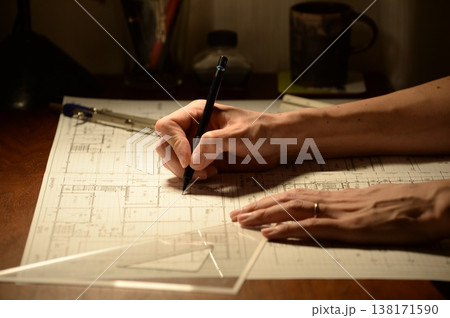 夜に建築図面を製図する日本人建築士の手元 138171590