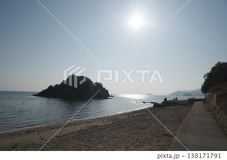 逆光の海と小さな島　静かな海辺の夕景風景 138171791