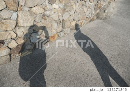 石垣に映る人物の影 写真を撮るシルエットと日差しのある風景 石垣に映る人物の影 写真を撮るシルエットと日差しのある風景 138171846