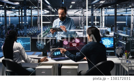 System administrators in data center struggle with computer bugs while using AI. Frustrated server farm coworkers doing brainstorming to fix system errors while using artificial intelligence, camera A 138172031