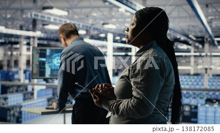 Teamworking data center programmers investigate neural networks configuration, making adjustments for optimal function. Server hub colleagues work together to check deep learning errors, camera B 138172085