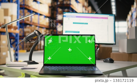 Empty warehouse depot running green screen on computer display, handling order processing and shipping e-commerce cargo products. Storage room with industrial racks and shelves. 138172119
