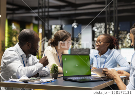 Green screen mockup laptop used by staff members in modern inclusive startup office. Coworkers presenting team leader key data statistics on chroma key isolated screen device after business audit 138172131