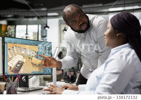 Black employees team using architectural CAD software for modern layout design, 3D rendering program on dual monitors. Architectural floor plan with tools and assets used for remodeling. 138172132