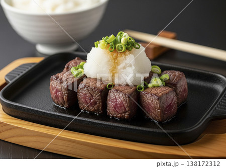 鉄板で香ばしく焼かれた和風おろしポン酢のサイコロステーキと青ねぎ 138172312