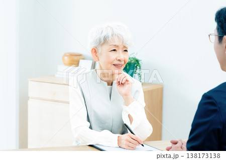 営業マンの説明を聞くシニア女性 138173138
