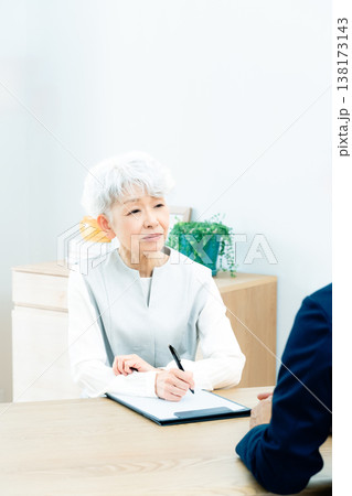 営業マンの説明を聞くシニア女性 138173143
