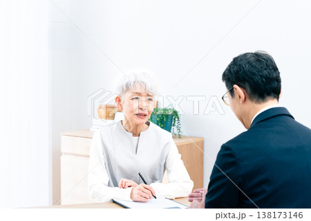 営業マンの説明を聞くシニア女性 138173146