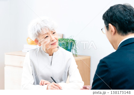 営業マンの説明を聞くシニア女性 138173148