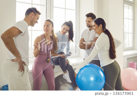 Health centre and fitness club sporty people talking with slim female coach Health centre and fitness club sporty people talking with slim female coach 138173901