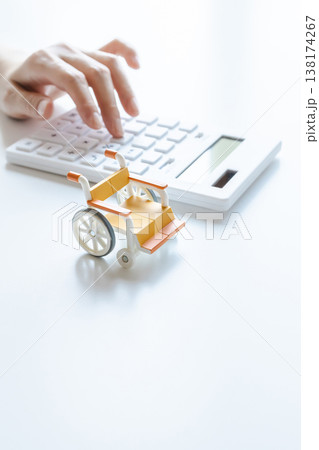 車椅子と計算機 介護費用や介護職の給料イメージ素材 車椅子と計算機 介護費用や介護職の給料イメージ素材 138174267