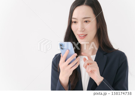 スマホを持って微笑むスーツの女性 スマホを持って微笑むスーツの女性 138174738