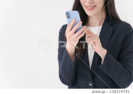 スマホを持って微笑むスーツの女性 スマホを持って微笑むスーツの女性 138174741