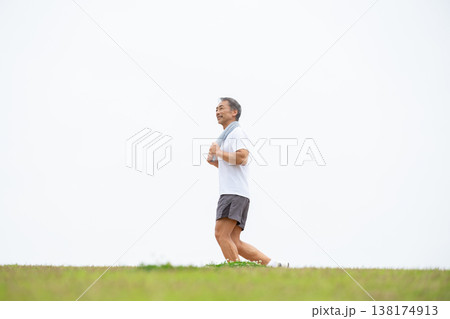 土手を歩く男性　ウォーキング 138174913